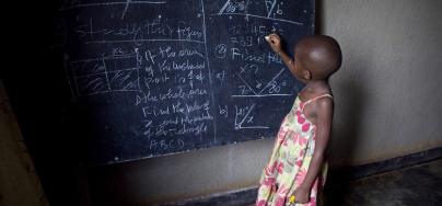 Una niña escribiendo en una pizarra, en una escuela de Ruanda. Foto: Simon Rawles / Oxfam