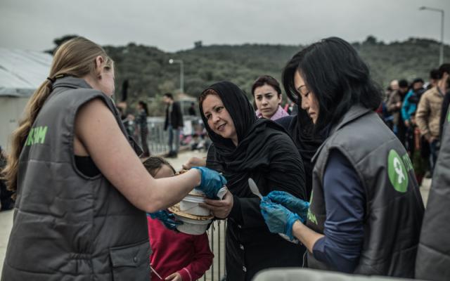 A group of Oxfam volunteers delivers food to migrants and refugees arriving in Lesbos, Greece. Credit: Pablo Tosco/Oxfam